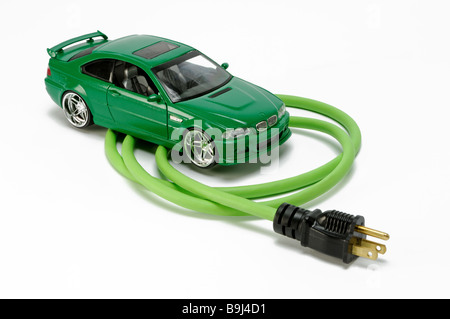 Ein grünes Auto Fahrzeug Auto mit einem grünen elektrischen Verlängerung Schnur Leistungsteil mit einem Stecker Stockfoto