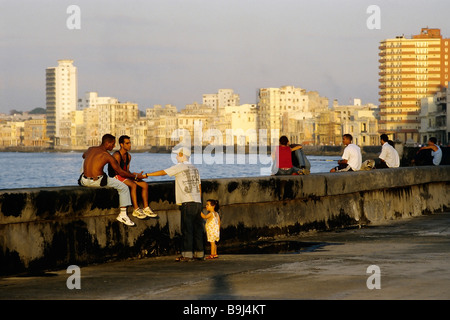 Abend Stimmung am Malecon, junge Leute sitzen an der Küste Wand, Skyline von Centro Habana, Havana, Kuba, Karibik Stockfoto