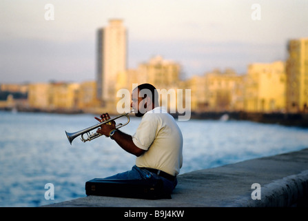 Farbigen Mann spielt Trompete, sitzen an Küste Wand auf dem Malecon, Havanna, Kuba, Karibik Stockfoto