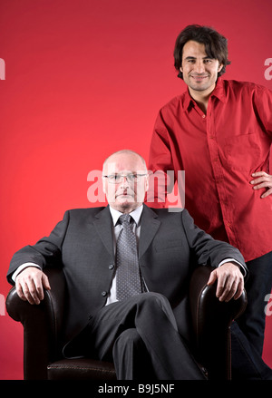 Geschäftsmann, sitzen in einem der Ledersessel mit seiner Assistentin Stockfoto
