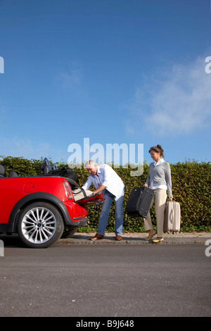 Älteres paar Taschen ins Auto setzen Stockfoto