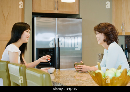 Mutter und Tochter sprechen in Küche Stockfoto