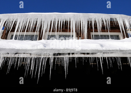 Eiszapfen hängen von einer Dachrinne Stockfoto