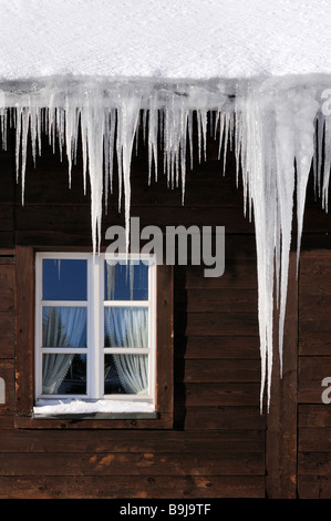 Eiszapfen hängen von einer Dachrinne Stockfoto