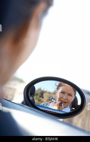 Frau Lippenstift in Auto Stockfoto