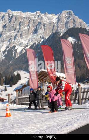 Kinder, die von einem Skilehrer in einem Anfängerkurs in einer Skischule vor Zugspitzmassivs, Ehrwald, Tyrol gelehrt, Stockfoto