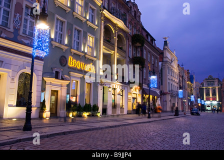 Weihnachtsbeleuchtung Linie Old Market Square (Stary Rynek), wie die Menschen vorbei an den Bars und Restaurants, Poznan, Polen gehen Stockfoto