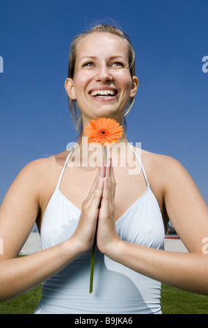 Frau junge blonde Gerbera-Blüte lächelnden Portrait-Serie Menschen Top String Top Blume Gerbera Sommerblume Entspannung Stockfoto