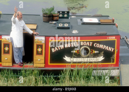 Ein Koch auf einem Hotel breiten Holzbalken Kanal Lastkahn auf dem Kennet und Avon Kanal bei Devizes in Wiltshire England Stockfoto