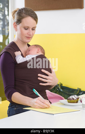 Mutter mit Baby im Tragetuch, schreiben Stockfoto