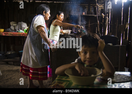 Frauen kochen über einen Holzofen in ihrem Haus in der Lacandon Maya Gemeinschaft von Naha, Chiapas, Mexiko. Stockfoto