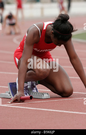 Afrikanische amerikanische weibliche Sprinter in den Startlöchern für die 4 x 100 Staffellauf Stockfoto