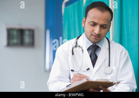 Arzt schriftlich auf einem Notizblock Stockfoto