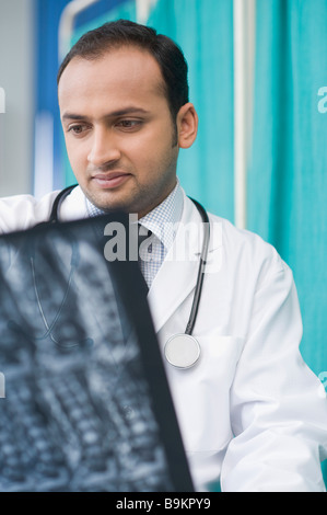Arzt untersucht einen Röntgen-Bericht Stockfoto