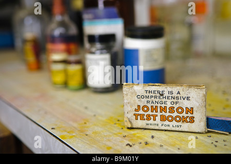 Box mit Johnson Test Bücher auf einem unordentlichen Labortisch mit Flaschen und Gläser von Chemikalien im Hintergrund. Stockfoto