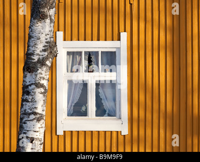 Weiße Fenster auf gelben Plank Wand, Finnland Stockfoto