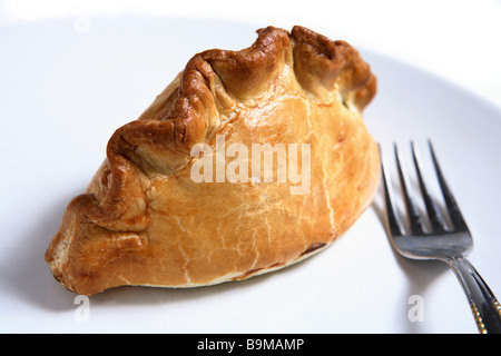 Eine traditionelle britische Cornish Pasty - Schrankes Gebäck gefüllt mit einer dicken Fleisch und Kartoffel-Eintopf - mit einer Gabel auf einem Teller. Stockfoto