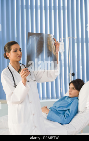 Ärztin untersucht einen Röntgen-Bericht Stockfoto