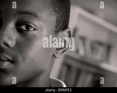Afrikanische amerikanische Schüler Teenager 13-15 Jahre schwarz afro-karibischen Junge Konzept männlicher Student Schüler emotionale halbe gesicht Auge portrait Schule Bibliothek B&W Stockfoto