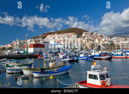 LOS CRISTIANOS Traditionelle bunte Fischerboote vertäut im Hafen von Los Cristianos mit Los Cristianos hinter Teneriffa Kanarische Inseln Spanien Stockfoto