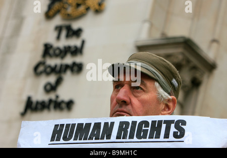 Ein Mann protestiert über "Menschenrechte" außerhalb der High Court auf dem Strang in der City of London, Vereinigtes Königreich. Stockfoto