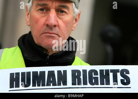 Ein Mann protestiert über "Menschenrechte" außerhalb der High Court auf dem Strang in der City of London, Vereinigtes Königreich. Stockfoto