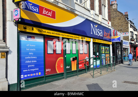 Shopper außerhalb von Nisa Business & Local Convenience Shop Front Rollstuhlzugang Rampe Western Union Schilder am Bow in Tower Weiler East London Großbritannien Stockfoto