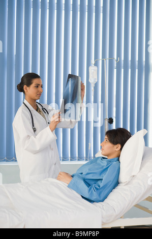 Ärztin untersucht einen Röntgen-Bericht Stockfoto