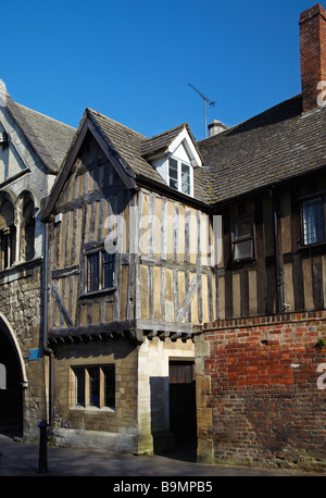 Halbe Fachwerkhaus neben St. Marien Tor, Kathedrale von Gloucester. Gloucester, England, Vereinigtes Königreich Stockfoto