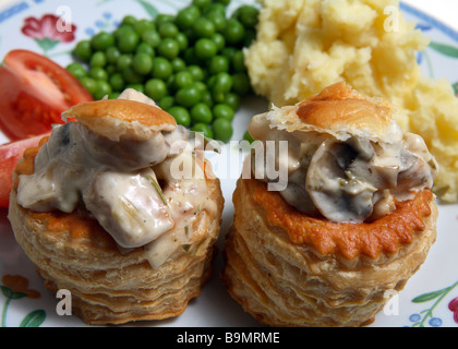 Ein Abendessen mit Huhn und Pilzen gefüllt Vol-au-vents mit Kartoffeln, Erbsen und Tomaten. Stockfoto