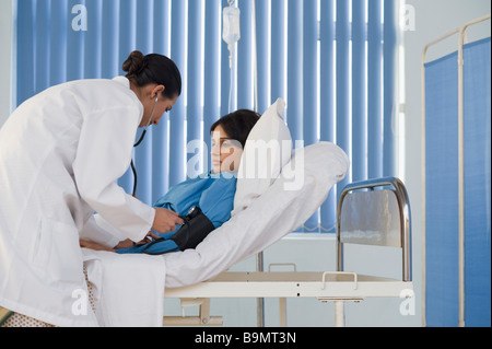 Ärztin Frau Blutdruck überprüfen Stockfoto