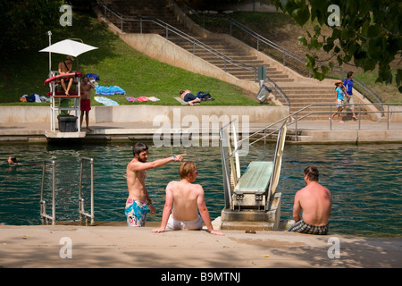 Austin, Texas - Jungs sitzen um das Sprungbrett an Barton Springs Pool in Austin, Texas Stockfoto