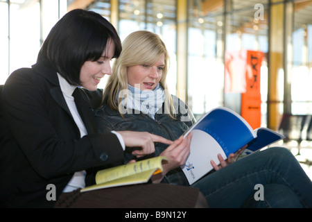 Frauen Schauen Reisekataloge ein Stockfoto