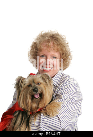 Eine liebenswerte Yorkie in einem roten Umhang und ihre glücklichen Besitzer isoliert Stockfoto