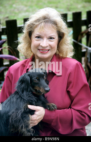 Eine glückliche lächelnde Frau und ihre entzückende schwarze langhaarige Daschund konzentrieren sich auf das Gesicht des Frau Stockfoto