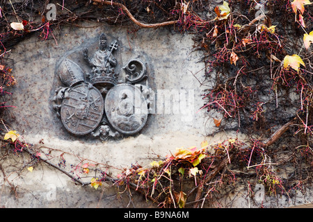 Strahov Kloster Wappen an Wand bedeckt mit Weinreben im Herbst. Stockfoto