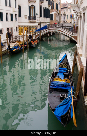 Venezianischen Kanal mit Gondel in den Vordergrund, die Brücke und die Reflexion von Gebäuden im Wasser, Venedig, Italien Stockfoto