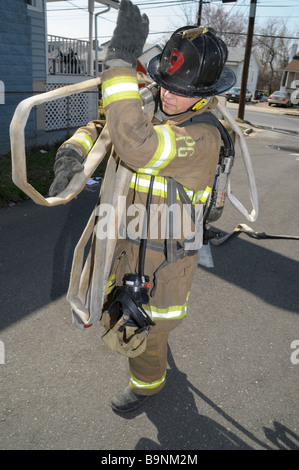 Feuerwehrmann mit Schlauch auf seiner Schulter in Bladensburg, Maryland Stockfoto