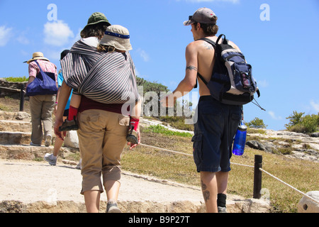 Tragen ein kleines Kind in einer Maya-Stil-Stoff-Schlinge während einer Tour durch die Ruinen in Yucatan Mexiko Stockfoto