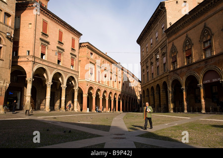 Ein Mann mit einer Zeitung geht über die Piazza di Santo Stefano in den frühen Morgenstunden Bologna Italien Stockfoto