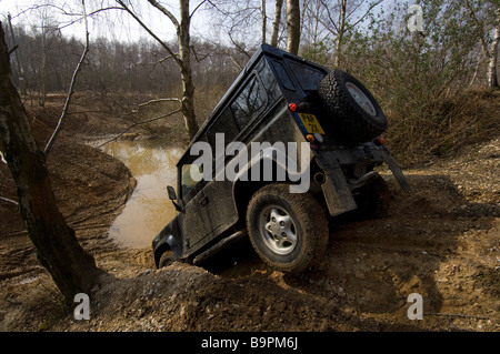 Ein Land Rover Defender 90 schleicht sich eine steile Böschung hinunter Stockfoto