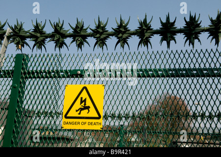 SICHERHEITSZAUN UND WARNUNG SCHILD AN EINEM STROM UMSPANNWERK. SCHILD STEHT LEBENSGEFAHR. Stockfoto