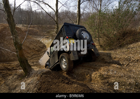 Ein Land Rover Defender 90 fahren eine steile Böschung hinunter während einer Off Road-Übung Stockfoto