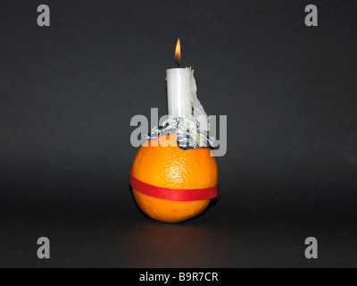 Christingle Orange symbolisiert die Welt, Kerze Jesus Christus das Licht der Welt und rotes Band das Blut Christi Stockfoto