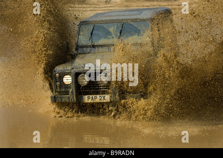 Ein Land Rover spritzt in einer überfluteten Straße. Stockfoto