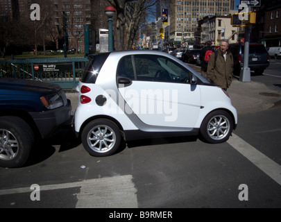 Ein zweisitziges Smart Auto hergestellt von Daimler ist gepresste in eine Parklücke in New York gesehen. Stockfoto