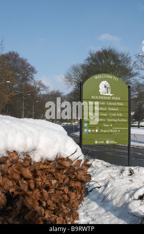 Schnee-Szene mit Bäumen und Sträuchern und Absicherung Straße durchzogen mit willkommen zu Roundhay Park Zeichen Stockfoto