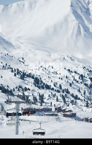 Sessellift in den französischen Alpen mit Ski Resort Dorf von Plagne Dörfer Plagne Soleil im Hintergrund Stockfoto