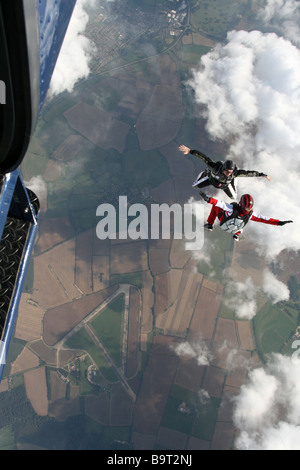 Zwei Fallschirmspringer springt aus einem Flugzeug in einer Position sitzen Stockfoto