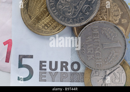 Ein Euro-Banknote mit alten europäischen Münzen Stockfoto